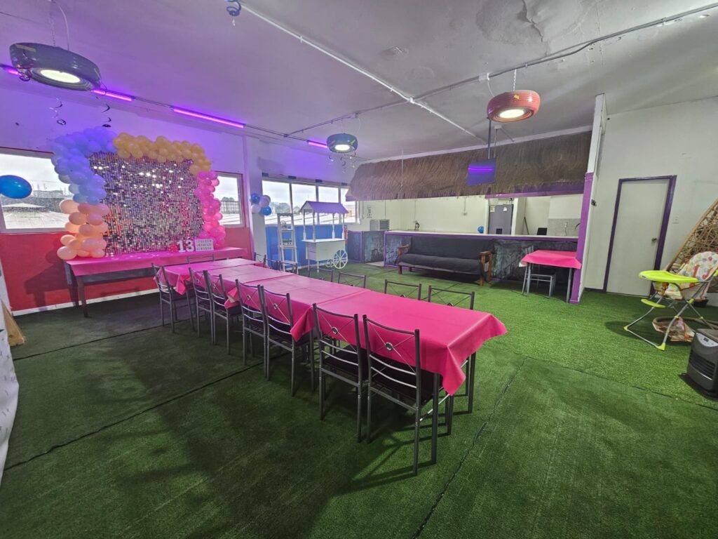 Salón de celebraciones decorado con globos y mesas para cumpleaños en Spring Jump